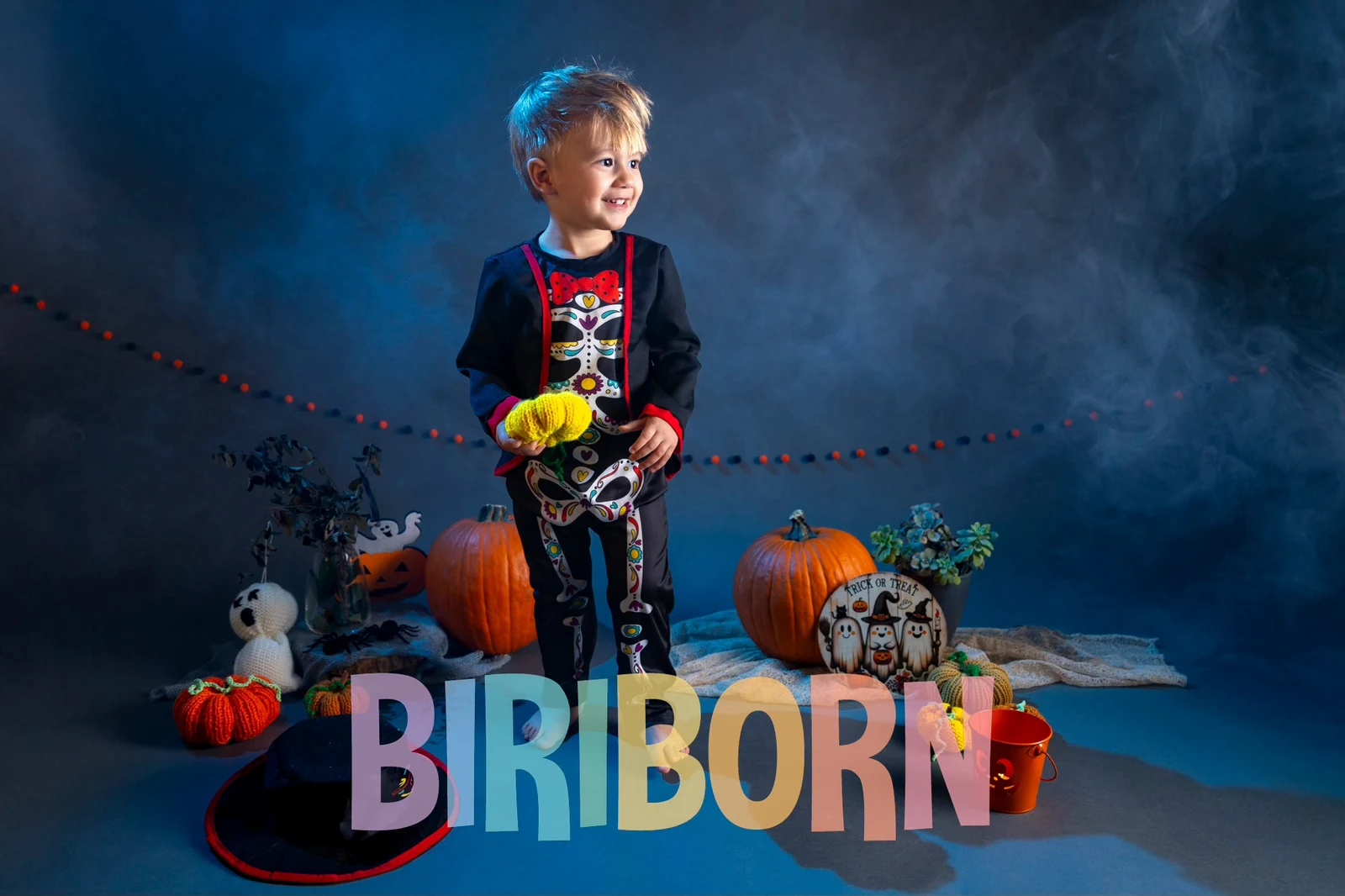 Bambino in costume da scheletro tra zucche e piccoli fantasmi