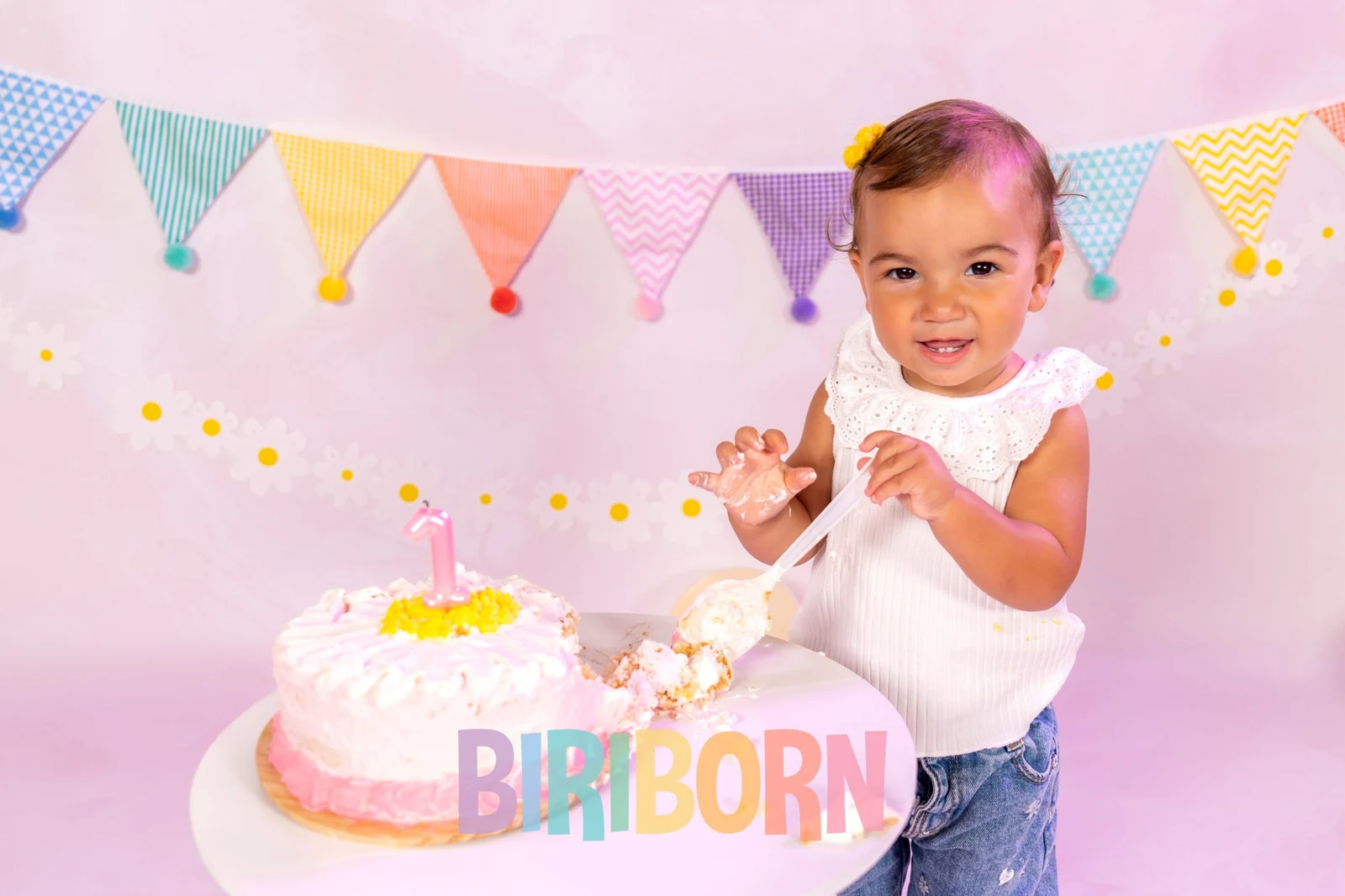 Azzurra sorride davanti alla torta con la candelina del primo compleanno